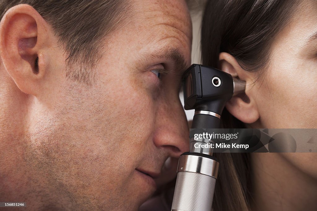 USA, Utah, Orem, close-up of doctor doing ear exam with Otoscope