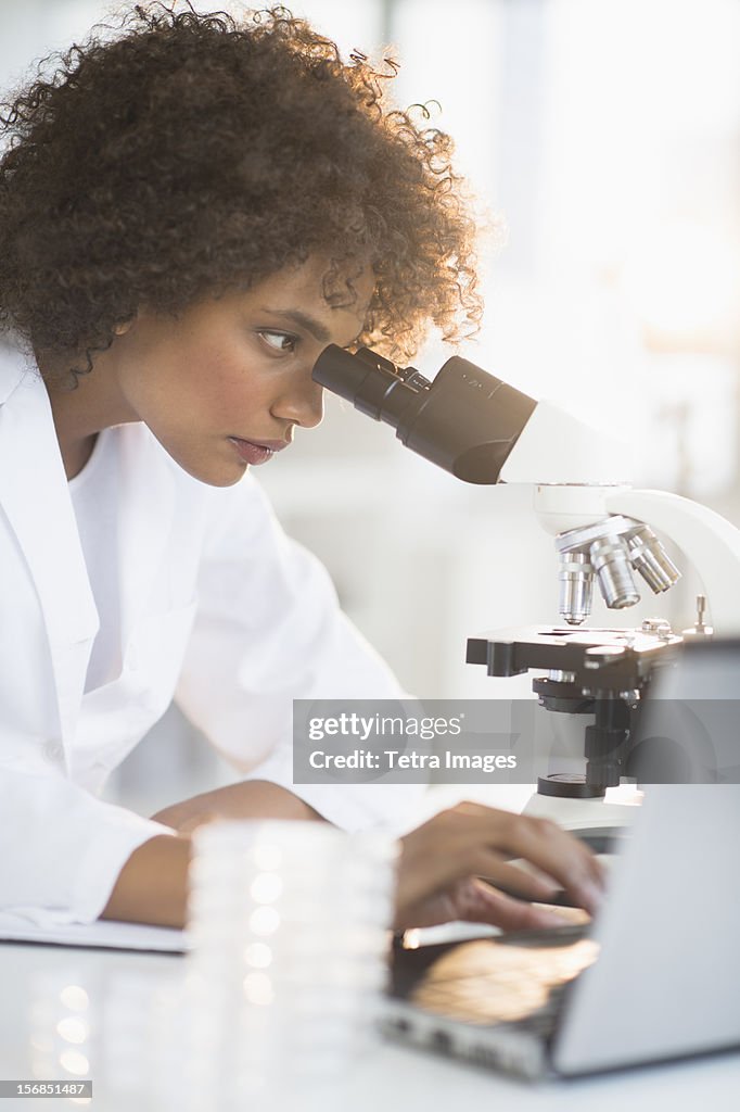 USA, New Jersey, Jersey City, Woman using microscope in laboratory