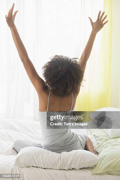 usa, new jersey, jersey city, woman stretching on bed - morning bed stretch fotografías e imágenes de stock