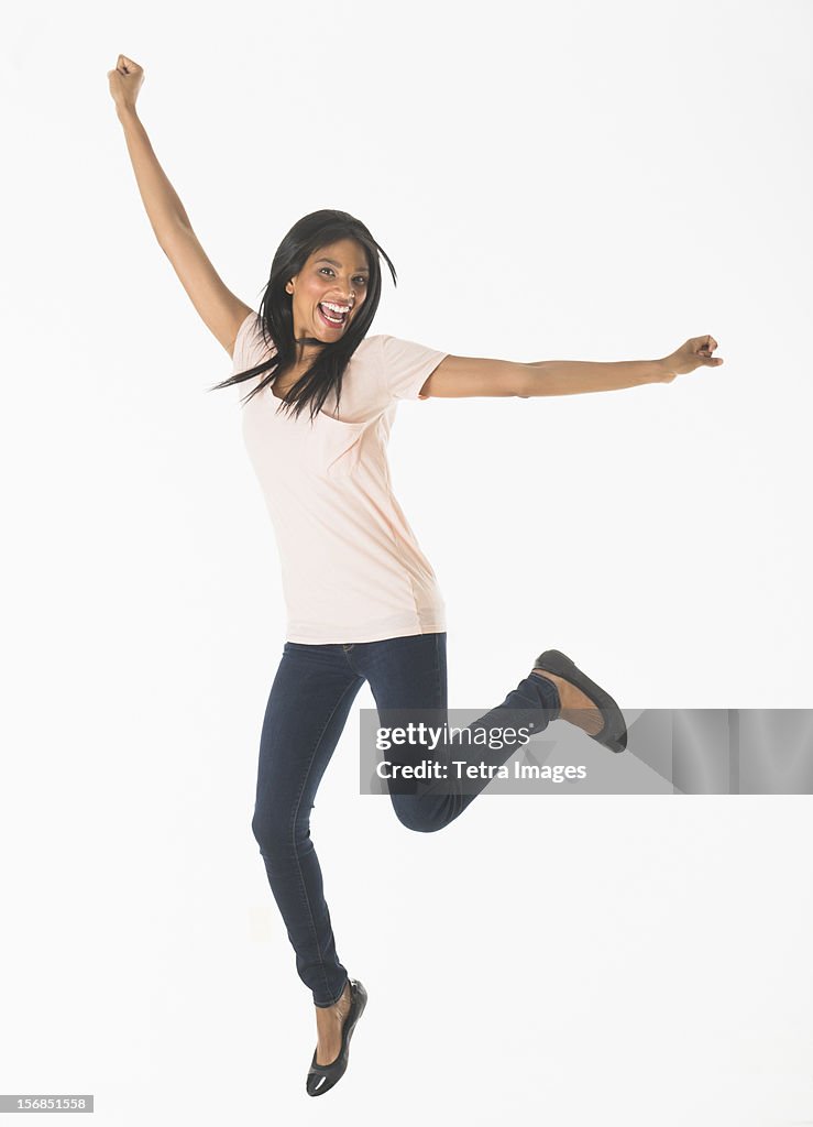 Portrait of woman jumping, studio shot