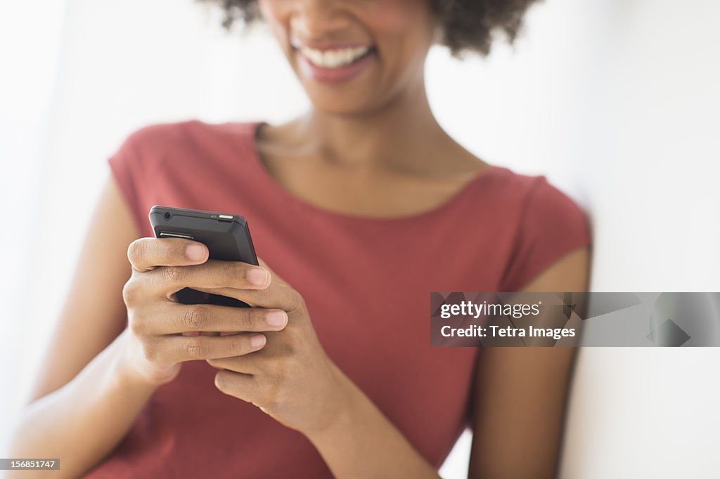 Woman using cell phone, studio shot