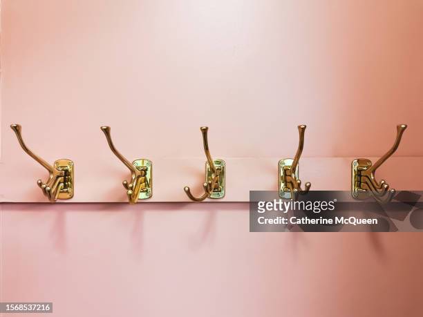 row of gold coat hooks - coat rack stock pictures, royalty-free photos & images