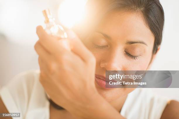 usa, new jersey, jersey city, woman smelling perfume on wrist - perfume stock-fotos und bilder