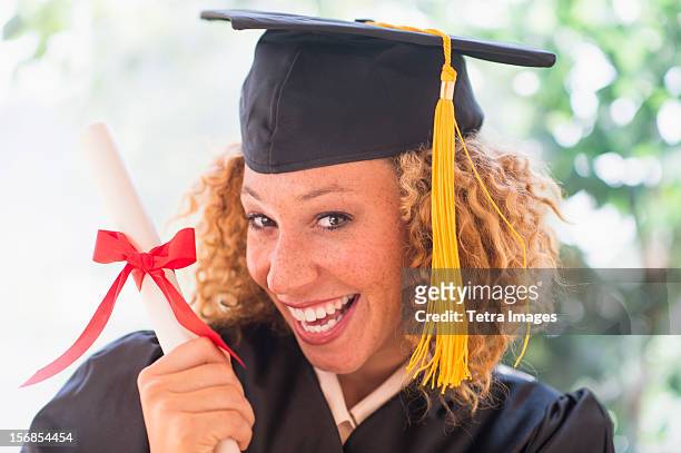 usa, new jersey, jersey city, portrait of smiling young woman in mortarboard showing diploma - close up of beautiful young blonde woman with black hat stock pictures, royalty-free photos & images