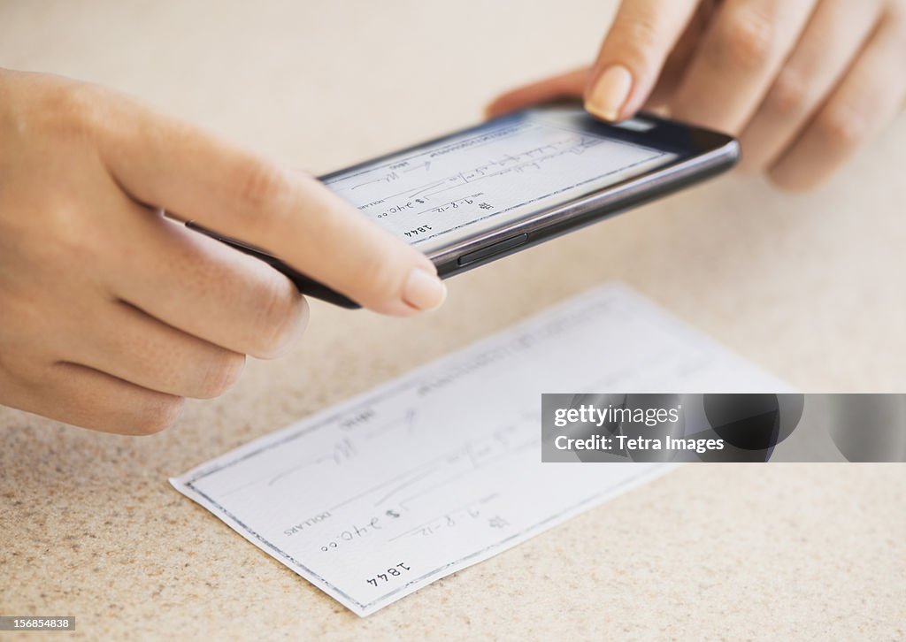 USA, New Jersey, Jersey City, Close up of woman's hand doing online banking with mobile phone