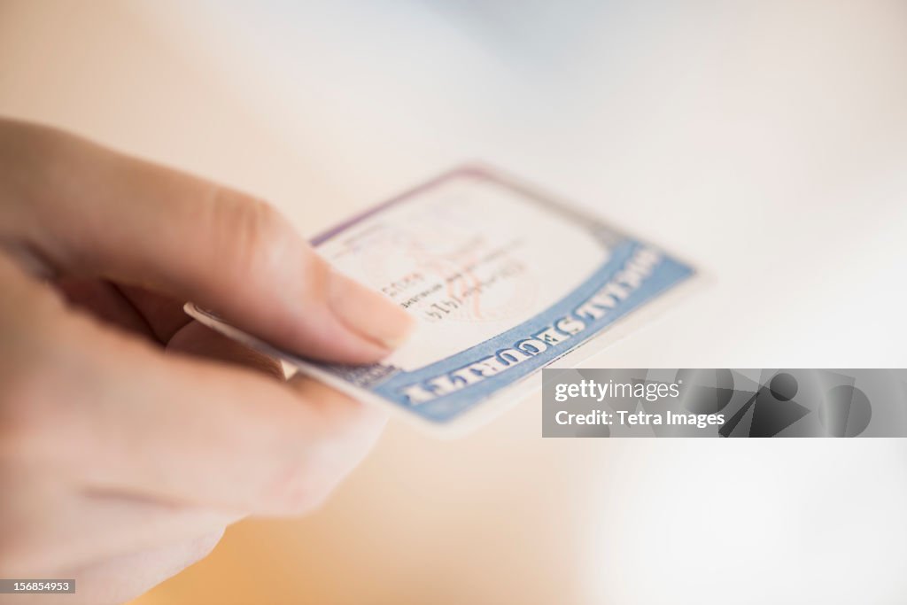 USA, New Jersey, Jersey City, Close up of woman's hand holding social security card