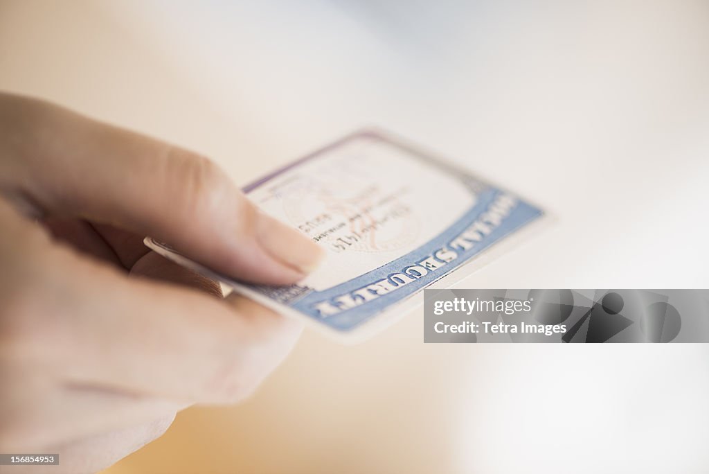 USA, New Jersey, Jersey City, Close up of woman's hand holding social security card