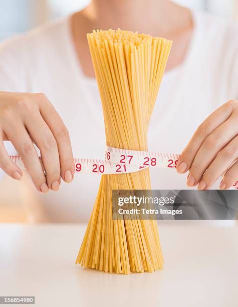 usa, new jersey, jersey city, close up of woman's hands measuring pasta with tape measure - woman measuring tape stock pictures, royalty-free photos & images