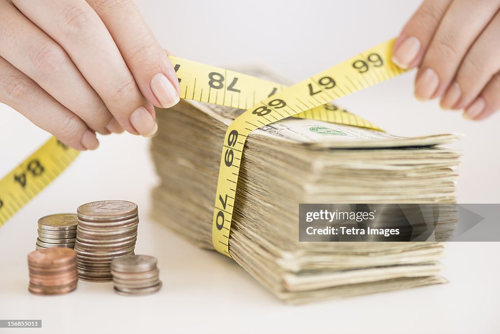 USA, New Jersey, Jersey City, Woman measuring bunch of banknotes