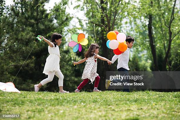 asian children playing outdoors - windrad natur wiese stock-fotos und bilder