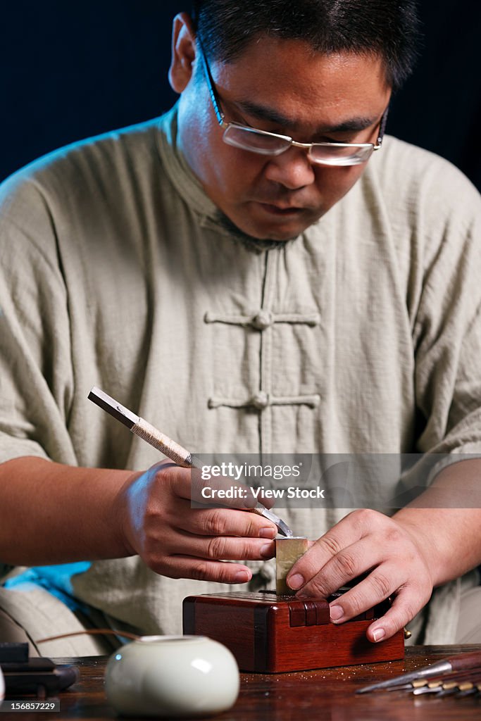 Craftsman carving Chinese character into a Chinese chop