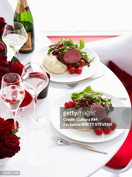 plates of beef with potatoes and salad - champange bottle and valentines day stock pictures, royalty-free photos & images