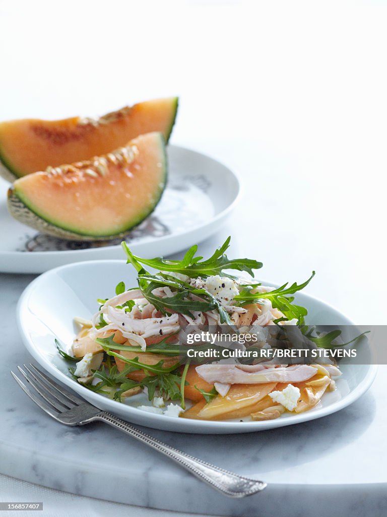 Plate of sliced melon and chicken
