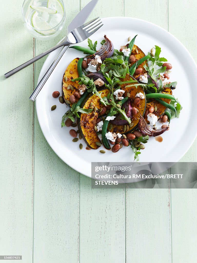 Plate of roasted pumpkin with salad