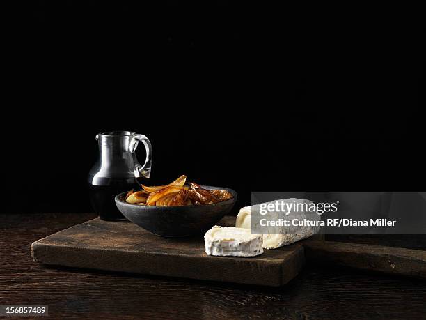 onions cheese and wine on board - henkelkrug stock-fotos und bilder