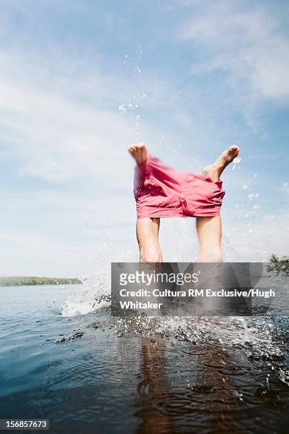 man pulling off shorts in lake - man skinny dipping stock pictures, royalty-free photos & images