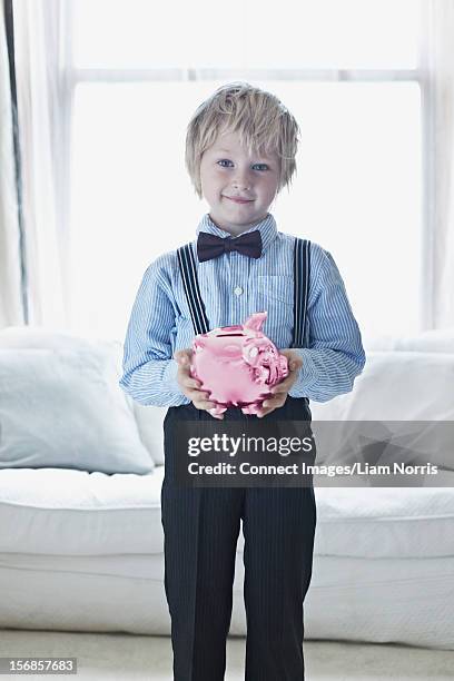 smiling boy in suit with piggy bank - blonde boy braces stock pictures, royalty-free photos & images