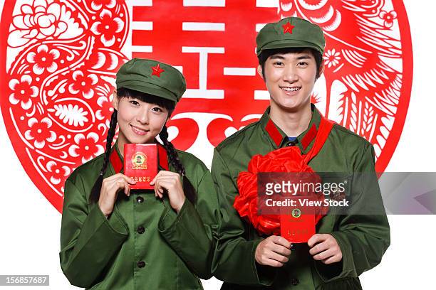 young couple in uniform - mao tse tung red book stock-fotos und bilder