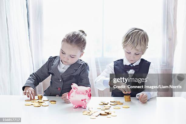 children in suits counting gold coins - pocket money uk stock pictures, royalty-free photos & images