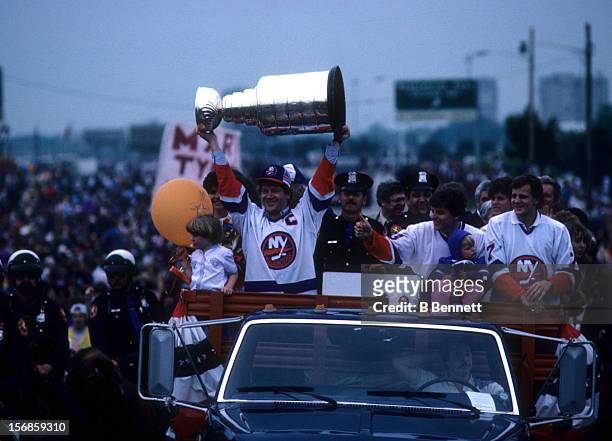 Denis Potvin of the New York Islanders shows the Stanley Cup Trophy to the crowd during the 1983 Stanley Cup Parade after they defeated the Edmonton...