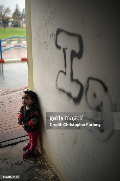 Two-year-old Namaa Kagan puts a bomb shelter to another use as she and her father take cover from torrential rain on November 23, 2012 in Sderot,...