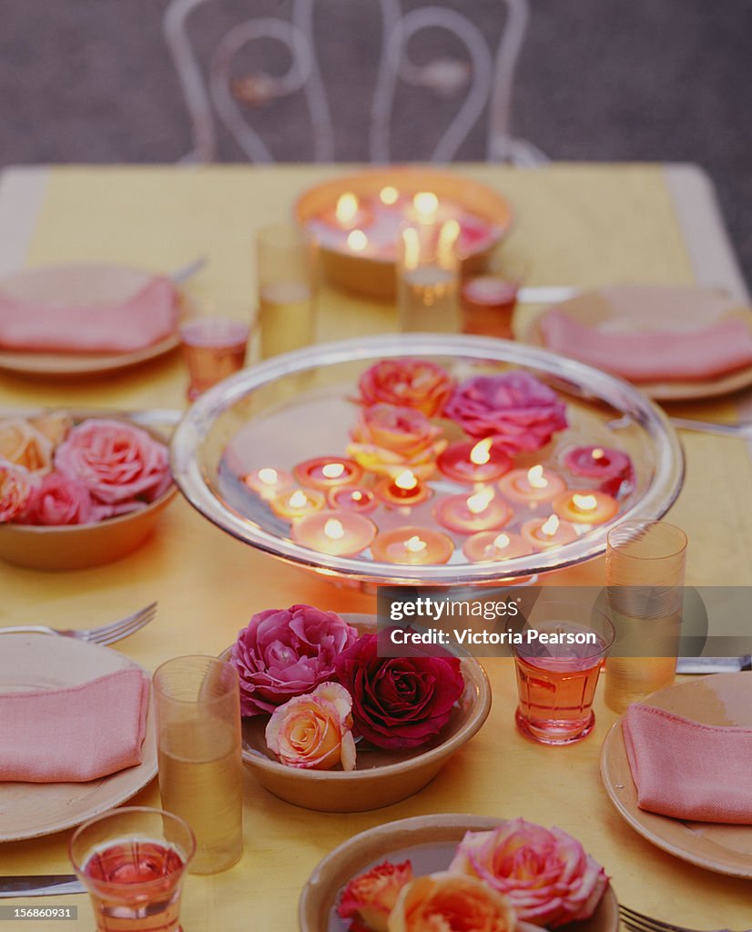 Roses and floating candles in bowls,