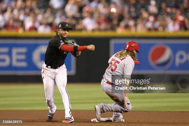 Infielder Ketel Marte of the Arizona Diamondbacks throws over Taylor Motter of the St. Louis Cardinals to complete a double play during the fourth...