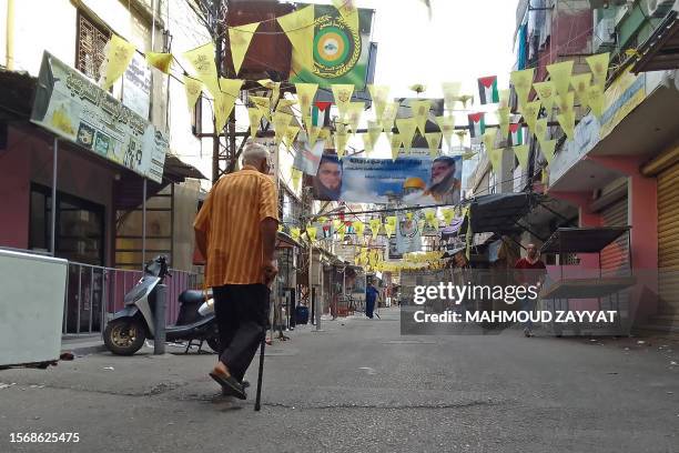 People walk past closed shops in the aftermath of clashes between the Fatah movement and Islamists inside the Ain el-Helweh Palestinian refugee camp...