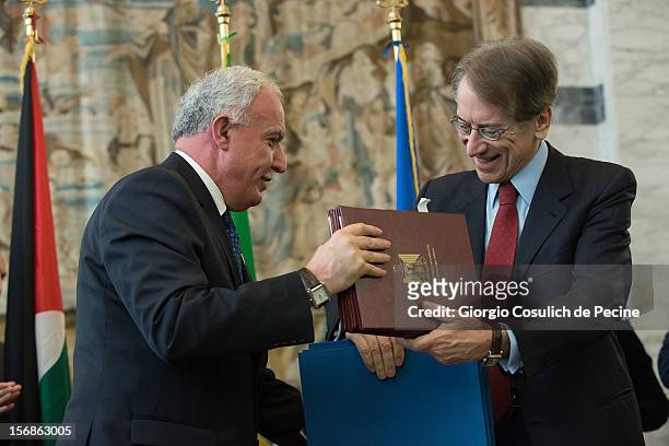 Palestinian Foreign Minister Riad Malki exchanges a bilateral agreement with Italian Foreign Minister Giulio Terzi during a minsterial committee at...