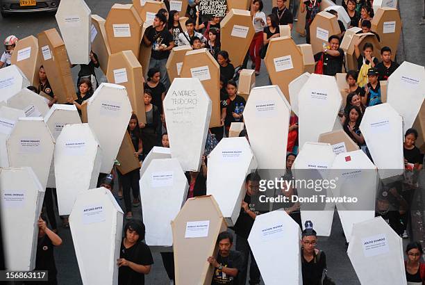 Filipino journalists and journalism students hold up mock coffins during the Remembrance Day Rally commemorating the 34 journalists massacred by...