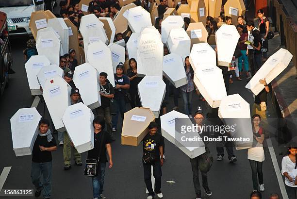 Filipino journalists and journalism students hold up mock coffins during the Remembrance Day Rally commemorating the 34 journalists massacred by...
