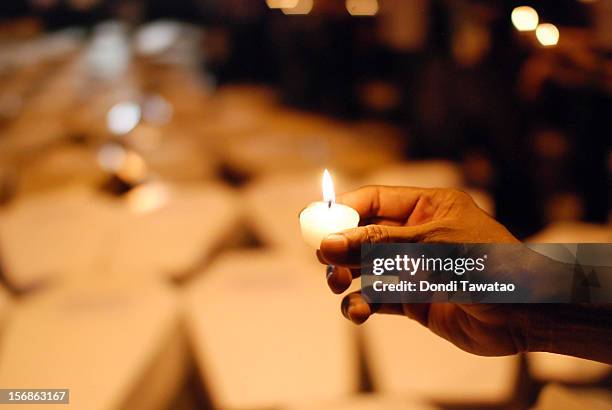 Filipino journalists and journalism students light candles in prayer during the Remembrance Day Rally commemorating the 34 journalists massacred by...