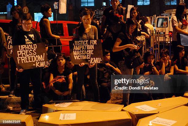 Filipino journalists and journalism students light candles in prayer during the Remembrance Day Rally commemorating the 34 journalists massacred by...