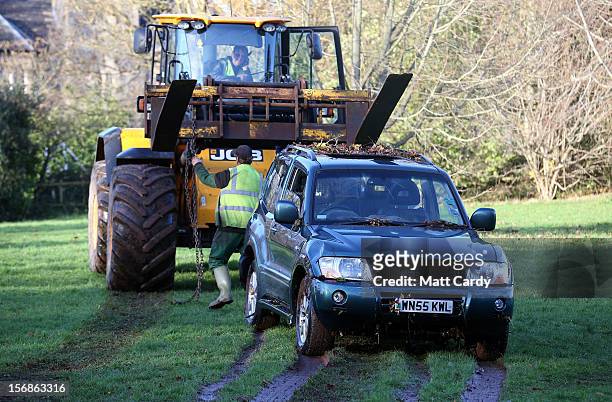 Car, in which a man died after being trapped in flood waters, is dragged by a JCB from under a bridge where it had got wedged last night, near to a...