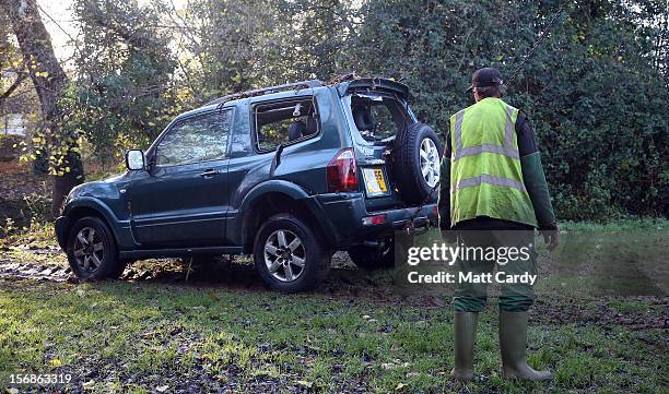 Car, in which a man died after being trapped in flood waters, is dragged by chains from under a bridge near to a ford at Rectory Fields, in Chew...