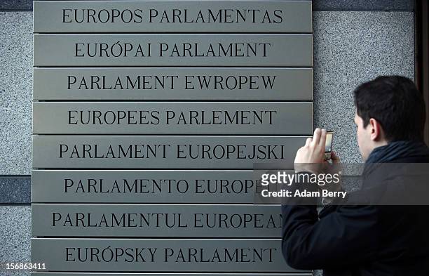 Visitor takes a picture of plaques in European languages identifying the European Parliament building on November 22, 2012 in Brussels, Belgium. A...