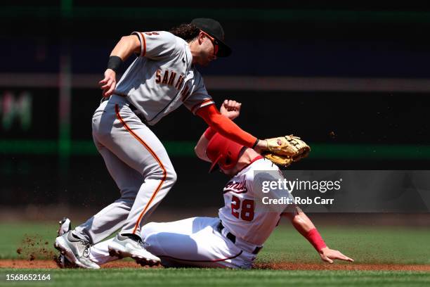 Lane Thomas of the Washington Nationals slides safely under the tag of Brett Wisely of the San Francisco Giants to steal second base in the first...