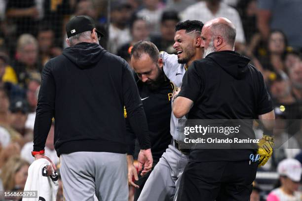 Tucupita Marcano of the Pittsburgh Pirates is helped off the field in the fifth inning against the San Diego Padres at PETCO Park on July 24, 2023 in...