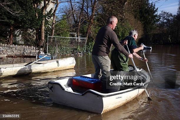 Two men use their boat to get through flood water that has covered the car park of Portavon Marina, on November 23, 2012 in Keynsham, England. A man...