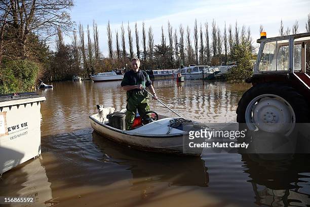 Man uses his boat to get through flood water that has covered the car park of Portavon Marina, on November 23, 2012 in Keynsham, England. A man died...