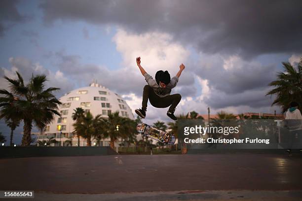Israeli youths practice their skate boarding skills near the beach in the southern Israeli town of Ashkelon on November 23, 2012 in Ashkelon, Israel....