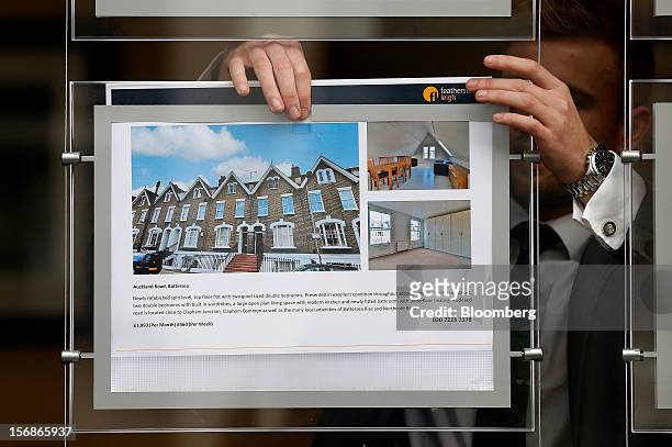 An employee places an advertisement for a rental apartment in the window display board of a Clapham estate agents, in London, U.K., on Friday, Nov....