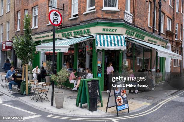 People having their lunch on tables outside the traditional breakfast cafe, the Fast Break Kozzy Cafe in Holborn on 9th July 2023 in London, United...