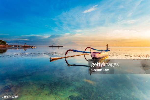 morning sun in bali, indonesia. traditional fishing boats at sanur beach, bali, indonesia. - activities in the sun stock-fotos und bilder