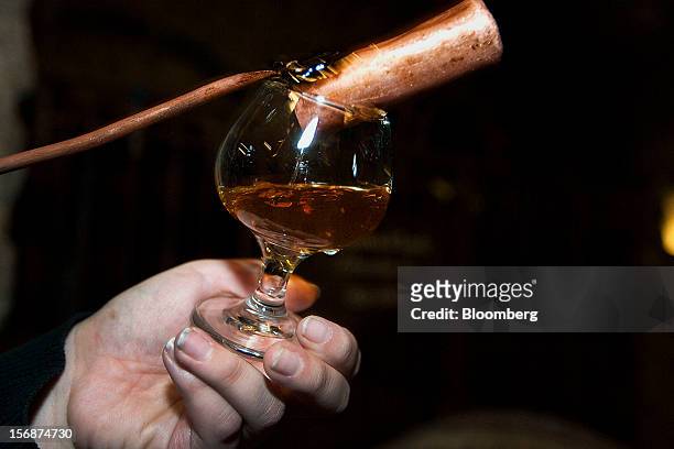 Aged tequila is poured into a glass to be served at the Tequila Cuervo La Rojena S.A. De C.V., maker of Jose Cuervo, distillery plant in Guadalajara,...