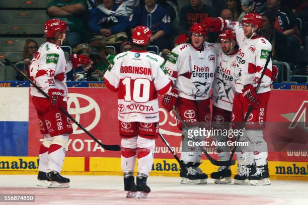 Felix Schuetz of Koeln celebrates his team's third goal with team mates during the DEL match between Adler Mannheim and Koelner Haie at SAP Arena on...