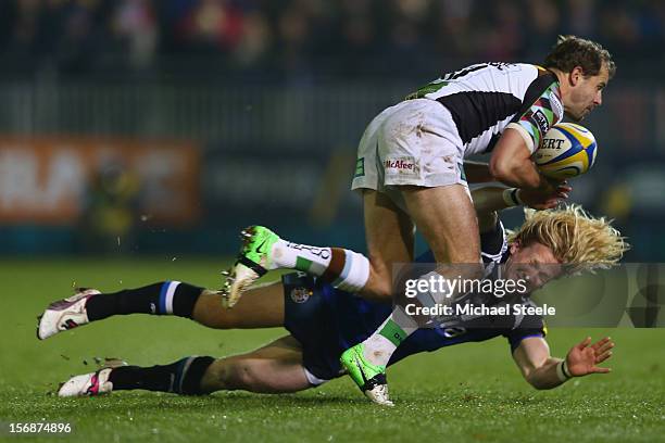 Tom Biggs of Bath falls under the challenge of Nick Evans of Harlequins during the Aviva Premiership match between Bath and Harlequins at the...