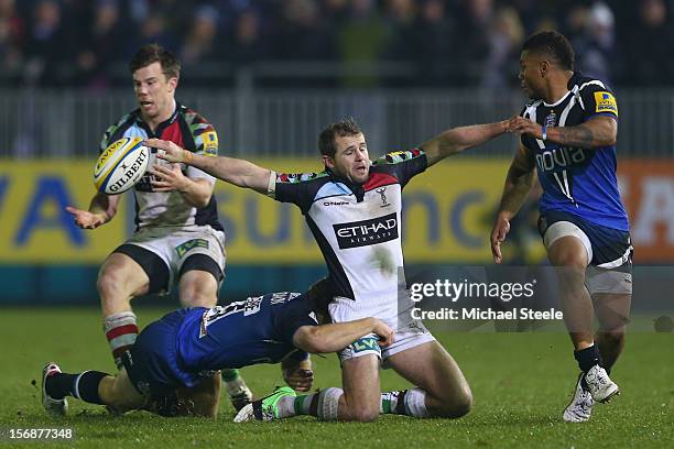 Nick Evans of Harlequins manages to offload to Sam Smith as Dave Attwood of Bath tackles and Kyle Eastmond looks on during the Aviva Premiership...
