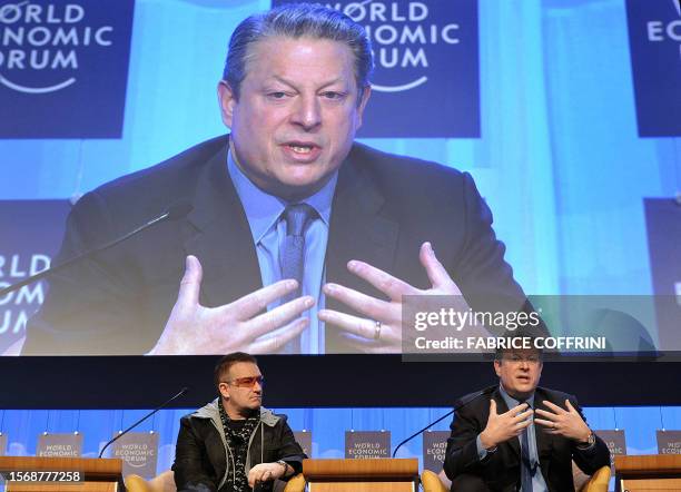 Irish rocker Bono listens as former US vice president and Nobel laureate Al Gore talks during a session at the World Economic Forum in Davos in 24...