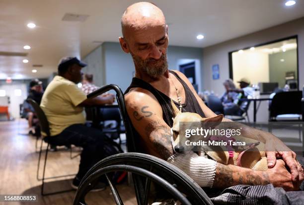 Cue Ball sits with his dog Baby Girl in the Justa Center, a cooling center for those 55 and older who are homeless, amid the city's worst heat wave...